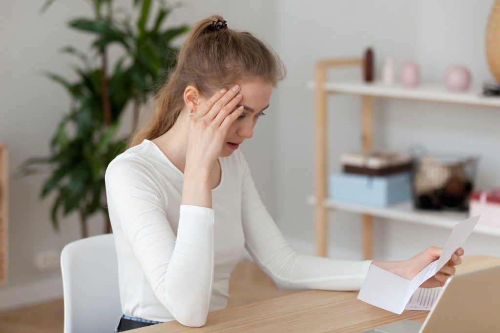 stressed woman looking at her bills