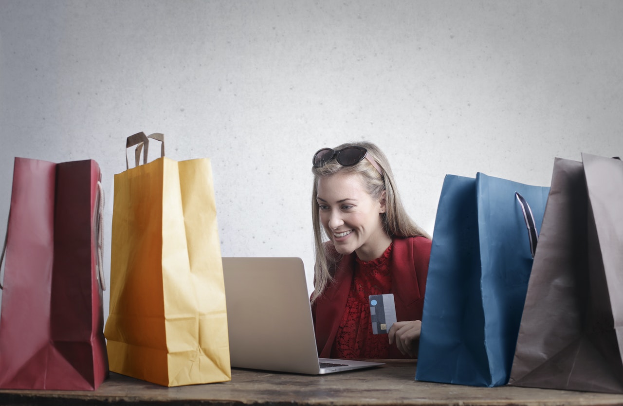 woman using her computer surrounded by paper bags