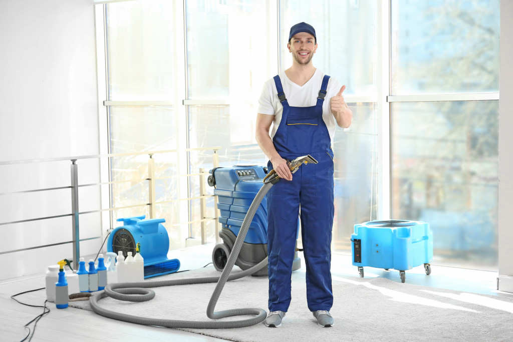 man holding the hose of a vacuum