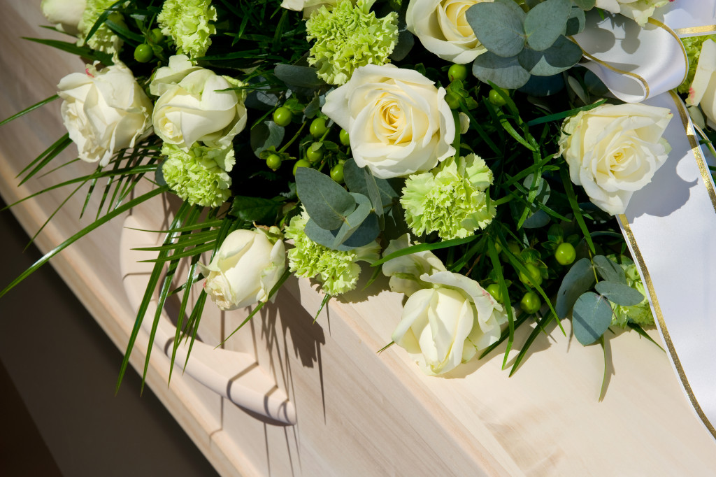 a coffin with white roses on top of it
