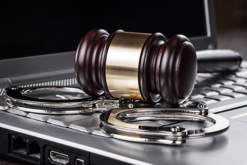 gavel with cuffs on top of a laptop