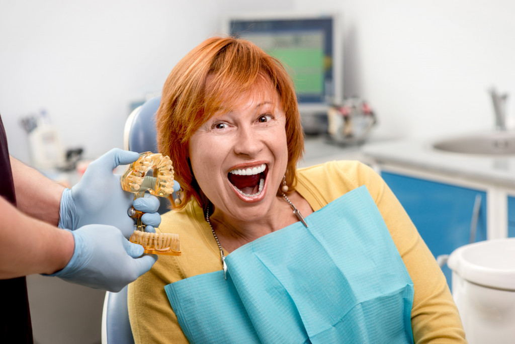 an aged woman with a big smile at a dental office