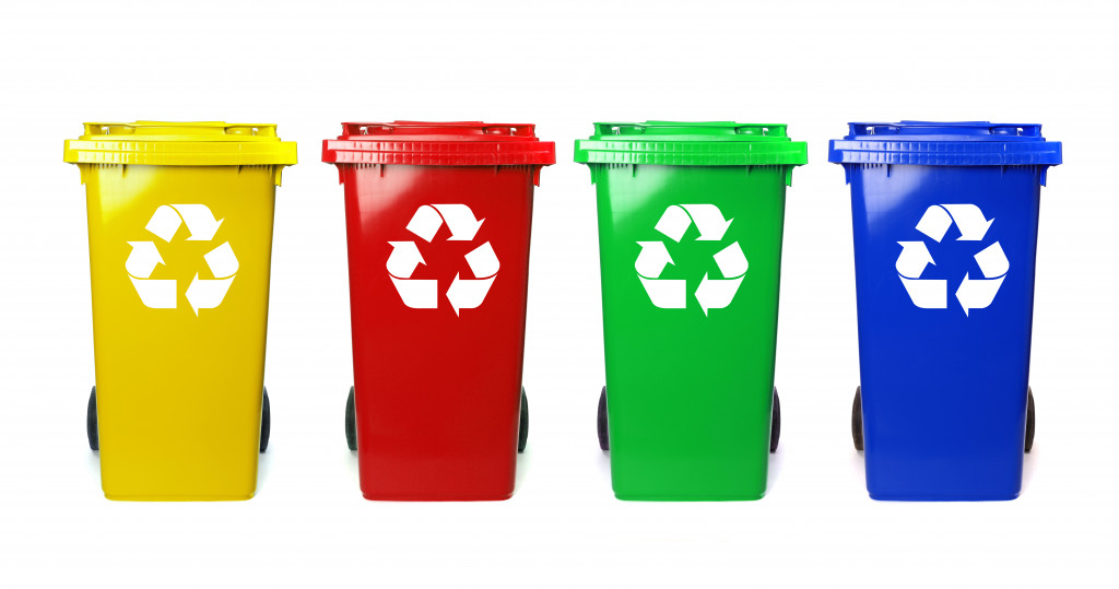 Four colorful dustbin yellow, red, green, and blue with recycle symbols on them